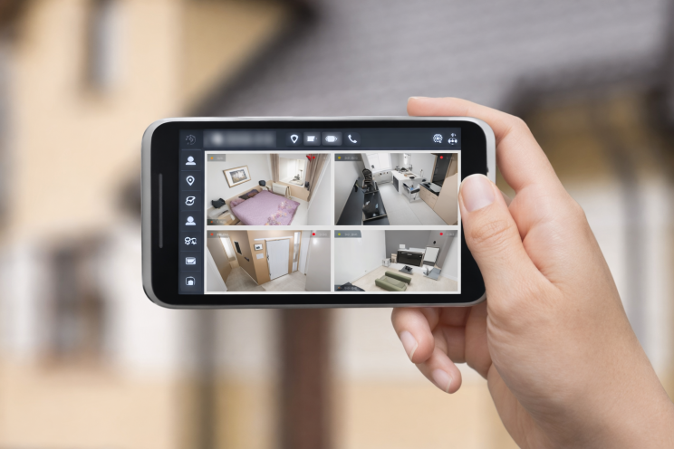 smartphone displaying phone monitoring app with multiple security camera feeds