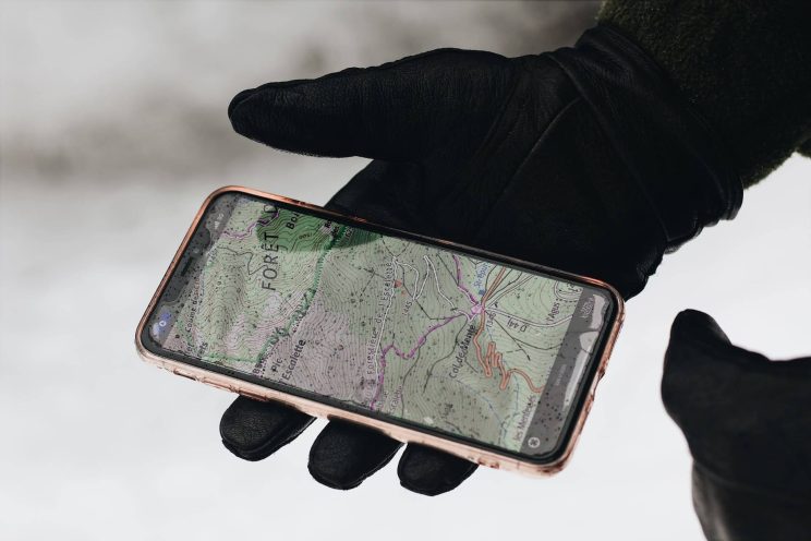 Smartphone displaying a phone number tracker app, tracking the location of a specific number