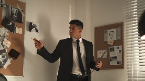Private investigator analyzing a corkboard covered with evidence and connecting clues.