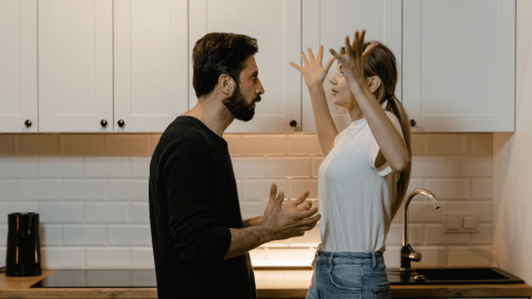 A couple engaged in a heated argument, with expressions of frustration and distress