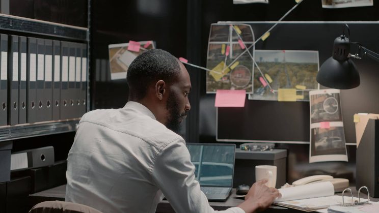 A man sitting at a table examining evidence.