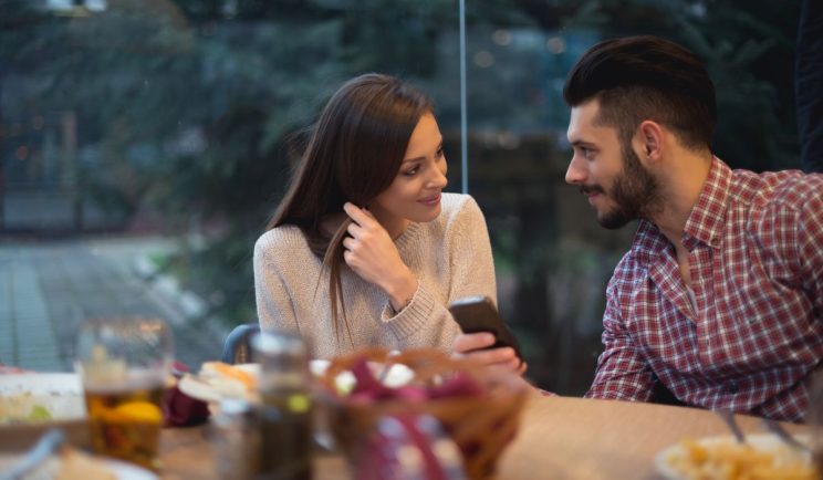 Two people having a friendly conversation at a desk in a modern office setting