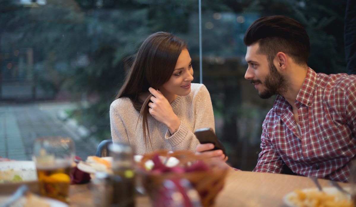 Two people having a friendly conversation at a desk in a modern office setting