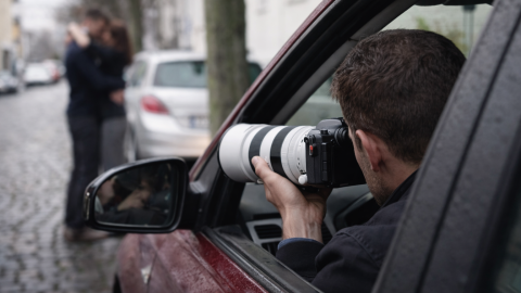 Private investigator in Brisbane Australia using a telephoto lens from inside a car observing a couple outdoors in a discreet surveillance operation