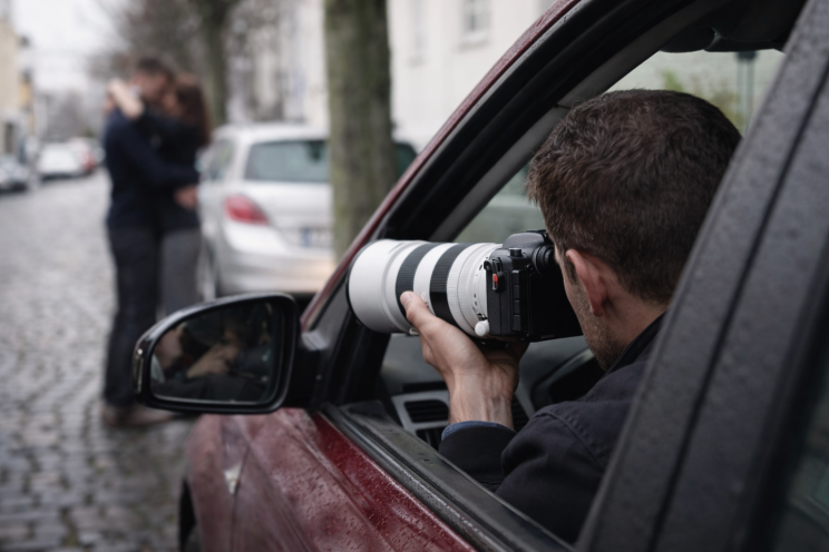 Private investigator in Brisbane Australia using a telephoto lens from inside a car observing a couple outdoors in a discreet surveillance operation